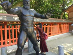 福岡県の住吉神社に参詣したとき、古代力士像の筋肉に触ろうとしている写真です
